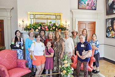 The First Lady poses with a group of women in the Ladies' Parlor at the Executive Mansion on Historic Garden Day.