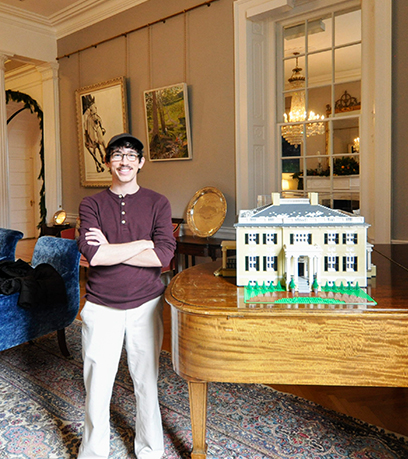 Benjamin Edlavitch standing with his LEGO model of the Executive Mansion.