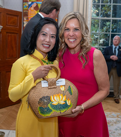 the First Lady and a woman holding a woven purse