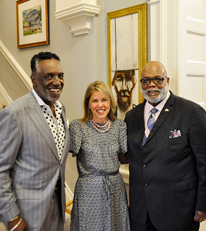 The First Lady poses with two fathers in front of a portrait of Abraham Lincoln.