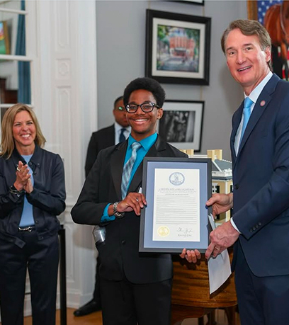 a young man receiving a certificate from the Governor