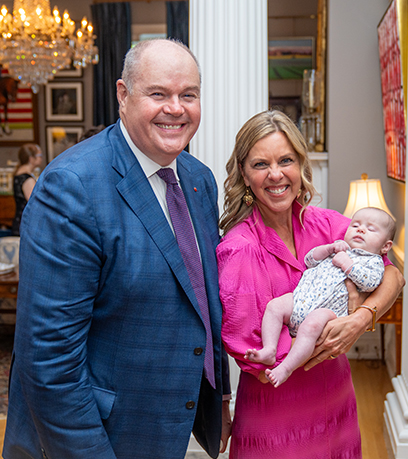 The First Lady holding a baby next to the child's father.