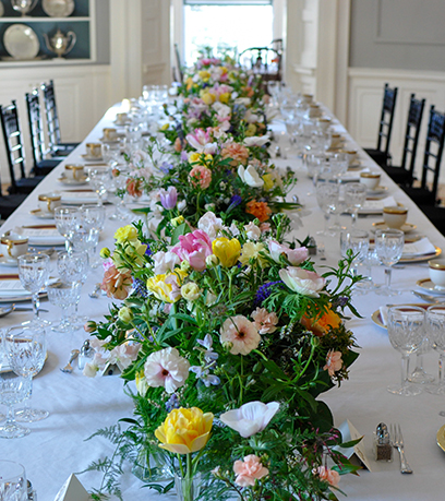 The Executive Mansion's dining table is set with a white table cloth, state china and flowers.