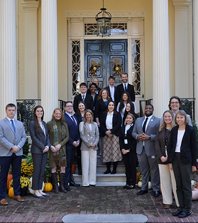 A group poses on the steps of the Executive Mansion.