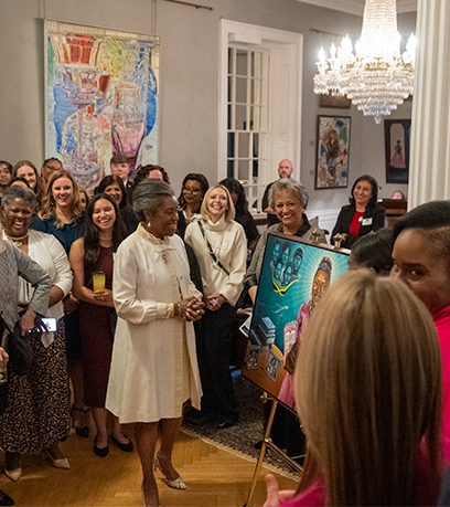 Lt. Gov. Sears stands in front of a crowd, getting a first look at her portrait painted by Sukenya Best.