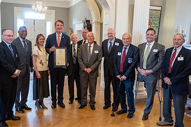 Governor Glenn Youngkin and the First Lady pose with a group of Vietnam War POWs.