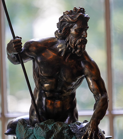 a bronze King Neptune statue illuminated by the natural light from a window in the Executive Mansion.