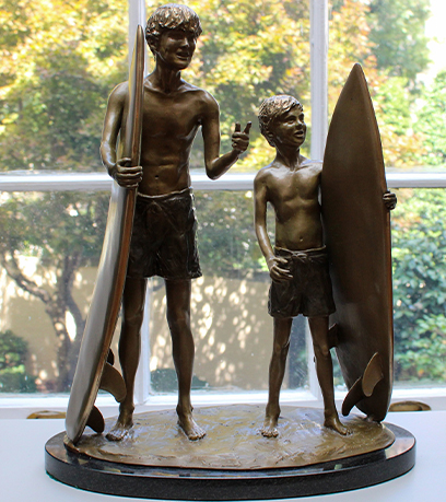 A sculpture of two young surfers