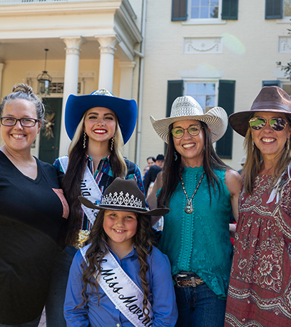 The First Lady poses with women and girls wearing cowboy hats.