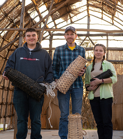 From left, David Onks, Brad Hatch and Reagan Andersen hold eel pots in a longhouse under construction at the Patawomeck Museum and Cultural Center in Fredericksburg on Sunday, December 11, 2022.